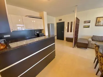 a kitchen with a counter and a living room at Garden of Eden Sea and Pool View in Sveti Vlas