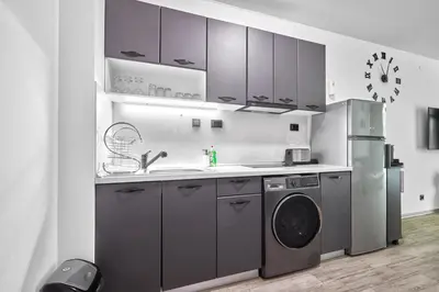 a kitchen with a sink and a washing machine at Paradise Apartments Primorsko in Primorsko