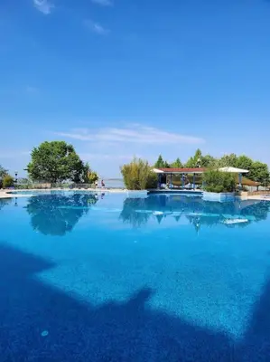 a large pool of blue water with trees in the background at Úchvatný výhled na moře in Aheloy