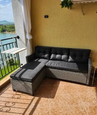 a couch sitting in a room with a balcony at Úchvatný výhled na moře in Aheloy