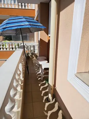 a row of benches with an umbrella on a balcony at Apartament Marinela 2 in Pomorie