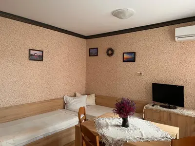 a living room with a table and a tv at Apartament Marinela 2 in Pomorie