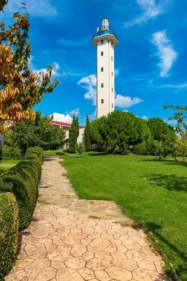 a stone path leading to a lighthouse in a park at Menada Aheloy Apartments in Aheloy