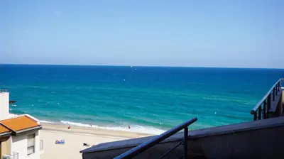 a view of a beach with people in the ocean at Апартаменти Обзор Бийч - Apartments Obzor Beach in Obzor