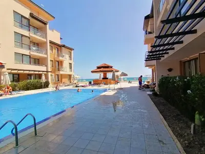 a swimming pool next to a building with people in it at Апартаменти Обзор Бийч - Apartments Obzor Beach in Obzor