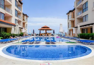 a pool at a hotel with chairs and umbrellas at Апартаменти Обзор Бийч - Apartments Obzor Beach in Obzor