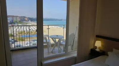 a bedroom with a balcony with a view of a beach at Апартаменти Обзор Бийч - Apartments Obzor Beach in Obzor