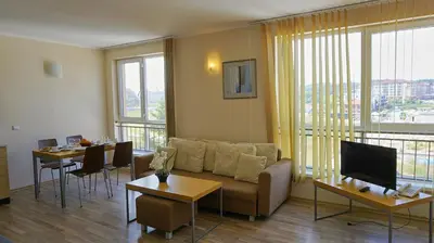 a living room with a couch and a table with chairs at Апартаменти Обзор Бийч - Apartments Obzor Beach in Obzor