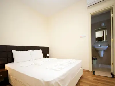a bedroom with a large white bed and a sink at Hotel Golden Ina - All Inclusive - Beachfront in Sunny Beach