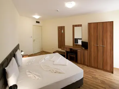 a bedroom with a bed and a desk and a television at Hotel Golden Ina - All Inclusive - Beachfront in Sunny Beach