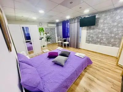 a bedroom with a purple bed with pillows on it at Studio 21 in Varna City