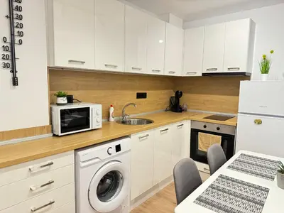 a kitchen with a washing machine and a microwave at Art Home in Burgas City