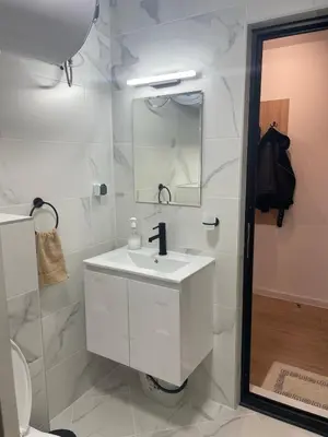 a white bathroom with a sink and a mirror at Art Home in Burgas City
