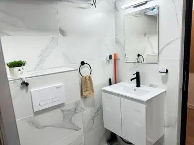 a white bathroom with a sink and a mirror at Art Home in Burgas City