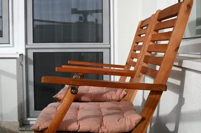 a wooden chair sitting in front of a window at The Swing in Burgas City