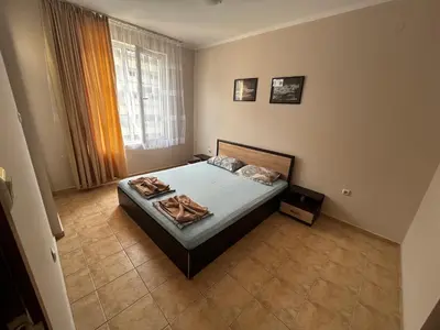 a bedroom with a bed in a room with a window at Апартамент Александър in Sunny Beach