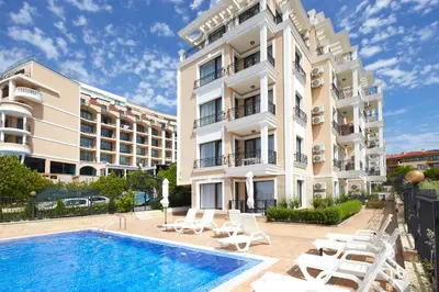 an apartment building with a swimming pool and lounge chairs at Mary Beach Resort Premium Apartments in Sveti Vlas
