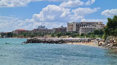 a beach with people in the water and buildings at Mary Beach Resort Premium Apartments in Sveti Vlas