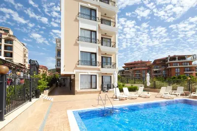 a building with a swimming pool in front of a building at Mary Beach Resort Premium Apartments in Sveti Vlas