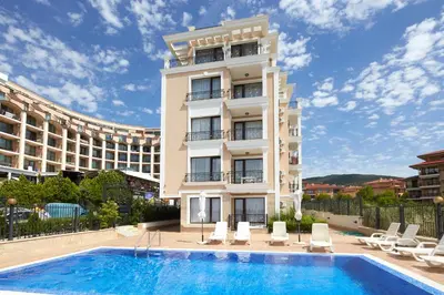 a hotel with a swimming pool in front of a building at Mary Beach Resort Premium Apartments in Sveti Vlas