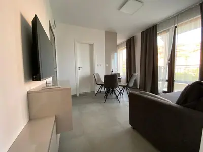 a living room with a couch and a table with chairs at Mary Beach Resort Premium Apartments in Sveti Vlas
