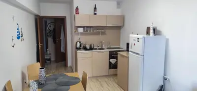 a small kitchen with a white refrigerator and a table at Complex Compass in Sveti Vlas