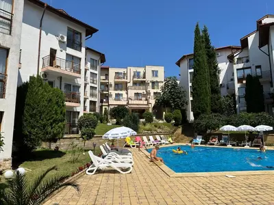 a hotel with a swimming pool and some chairs and buildings at Complex Compass in Sveti Vlas