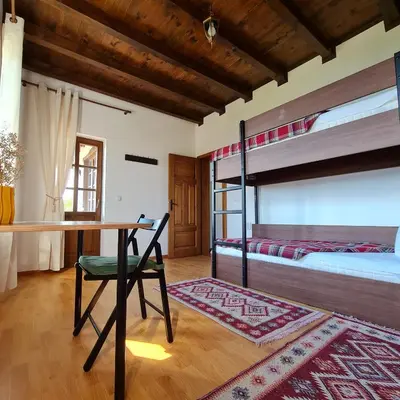 a bedroom with a desk and a bunk bed at Eco Lodge St Ignatius Еко лодж Игнажден in Debelets