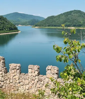 a view of the lake from the ruins of a stone wall at Eco Lodge St Ignatius Еко лодж Игнажден in Debelets