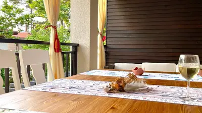 a wooden table with a glass of white wine at SeaRent Dream Home in Santa Marina - 2 bedrooms, 2 baths and a HUGE terrace in Sozopol