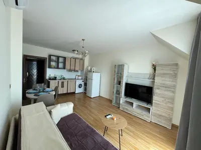 a living room with a couch and a kitchen at Golden Hermes Apartments in Sunny Beach