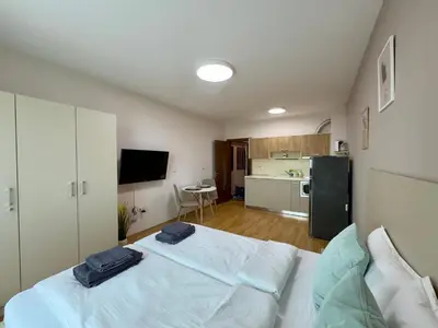 a bedroom with a bed with two blue towels on it at Golden Hermes Apartments in Sunny Beach