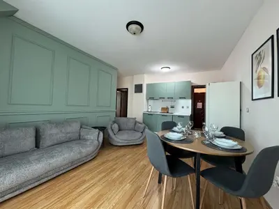 a living room with a couch and a table with chairs at Golden Hermes Apartments in Sunny Beach