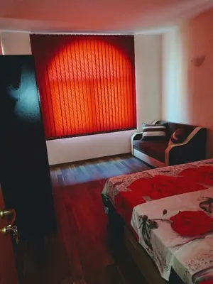 a bedroom with a bed and a red window at Ред хаус in Sunny Beach