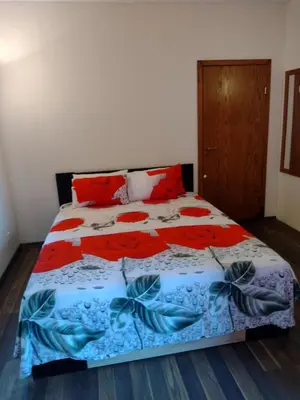 a bedroom with a bed with a blue and red bedspread at Ред хаус in Sunny Beach