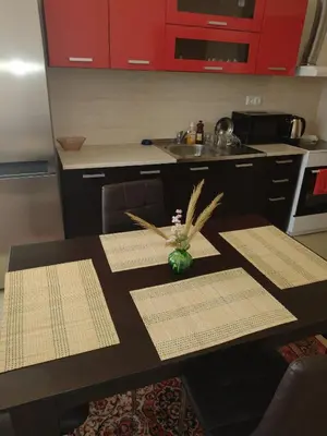 a kitchen with a table with a vase of flowers on it at Ред хаус in Sunny Beach