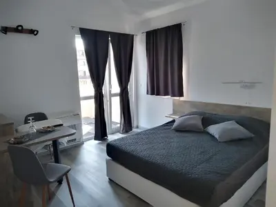 a bedroom with a bed and a desk and a window at July's Guest House in Primorsko