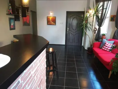 a living room with a red couch and a bar at Guest House Sunflowers in Pomorie