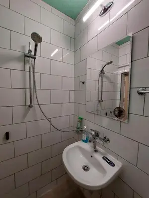 a white bathroom with a sink and a mirror at Студио Тони in Burgas City