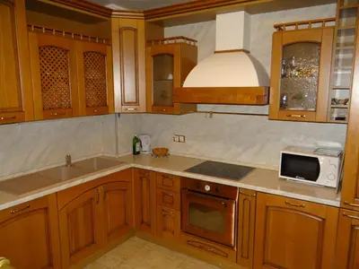 a kitchen with wooden cabinets and a sink and a microwave at Luxury Versailles Apartments Center Opera in Burgas City
