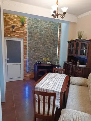 a living room with a table and a brick wall at Cozy flat Sisilia center in Varna City
