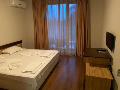 a hotel room with a bed and a television at Diamond Beach Apartment 2 Room in Burgas City
