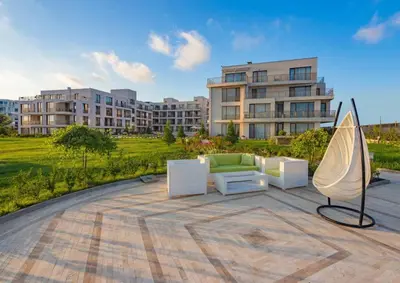 a patio with a couch and a umbrella and a building at Diamond Beach Apartment 2 Room in Burgas City