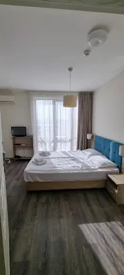 a bedroom with a large bed and a large window at APART SUN Travel SUNNY BEACH in Sunny Beach
