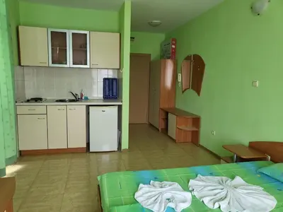 a room with a kitchen and a bed with towels at Complex ELIT Cacao Beach - Apartments for rent- ЕЛИТ Слънчев бряг in Sunny Beach