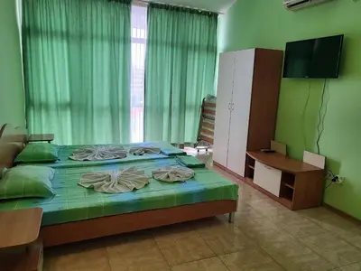 a bedroom with a bed with a television and a window at Complex ELIT Cacao Beach - Apartments for rent- ЕЛИТ Слънчев бряг in Sunny Beach