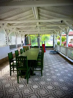 a dining room with a green table and chairs at Guest House PETRA- Medovo, Sunny beach in Razvalini Balchikioy