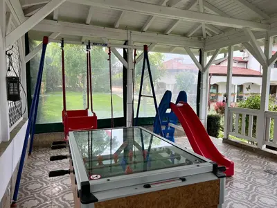 a swing set in a pavilion with a game at Guest House PETRA- Medovo, Sunny beach in Razvalini Balchikioy
