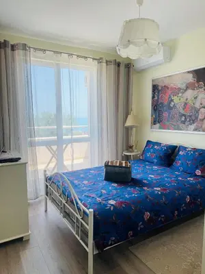 a bedroom with a bed with a view of the ocean at Kiwi Gardens in Byala