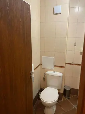 a bathroom with a white toilet in a room at Хотел ЮГ in Primorsko